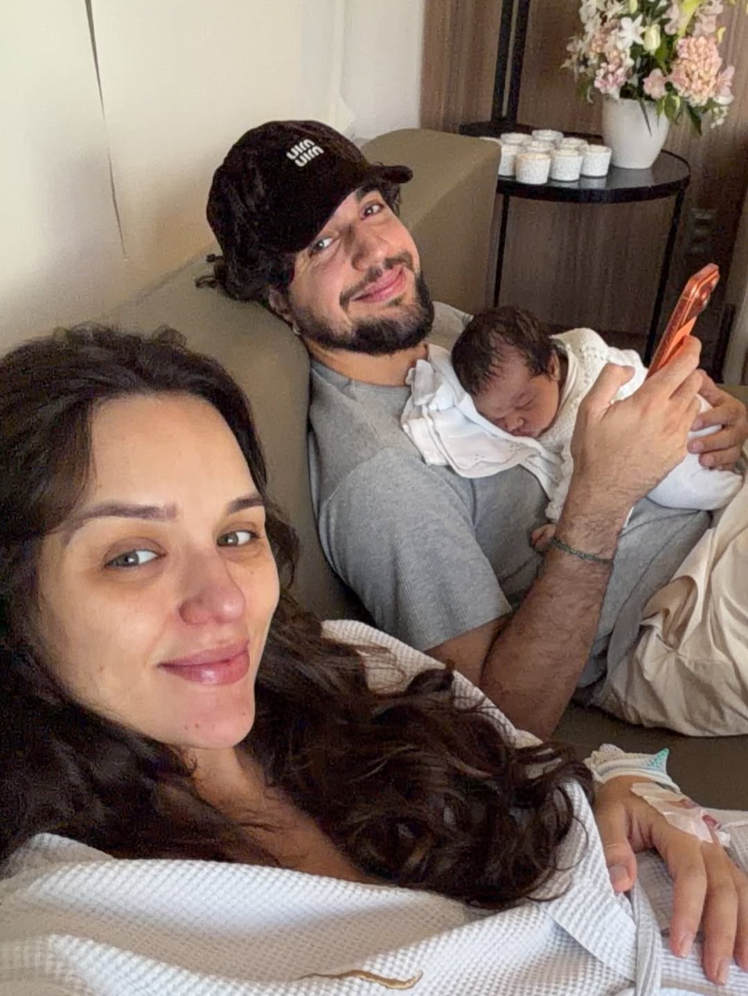 Rafa Kalimann fala sobre ausência de Nattan na gestação e gera repercussão 6 Casal Rafa Kalimann e Nattan deitados no sofá com a filha Zuza Helena recém-nascida no colo do pai