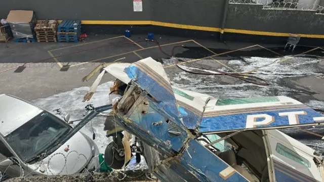 Tudo que se sabe sobre o avião que bateu em prédio nesta segunda, 04 6 Avião azul destruído com prefixo PT visível sobre carro branco em estacionamento após queda em Belo Horizonte
