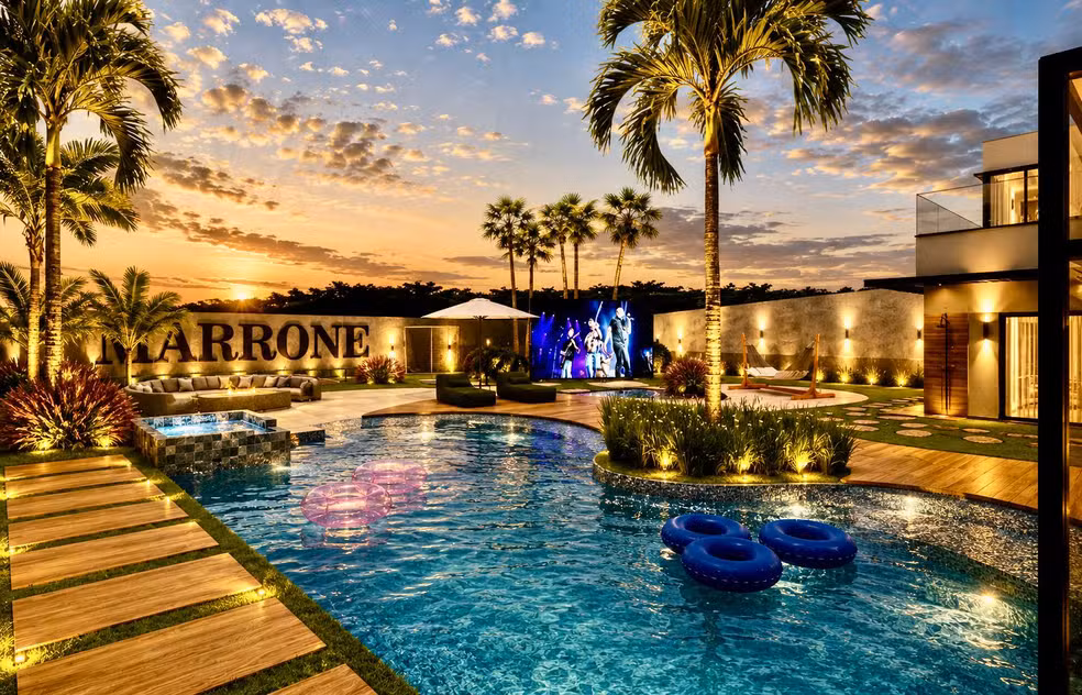 Mansão de Marrone: 5 espaços de tirar o fôlego que transformam o lar num resort exclusivo 7 Projeto da mansão de Marrone com piscina estilo resort, palmeiras, telão LED e letreiro com nome do cantor