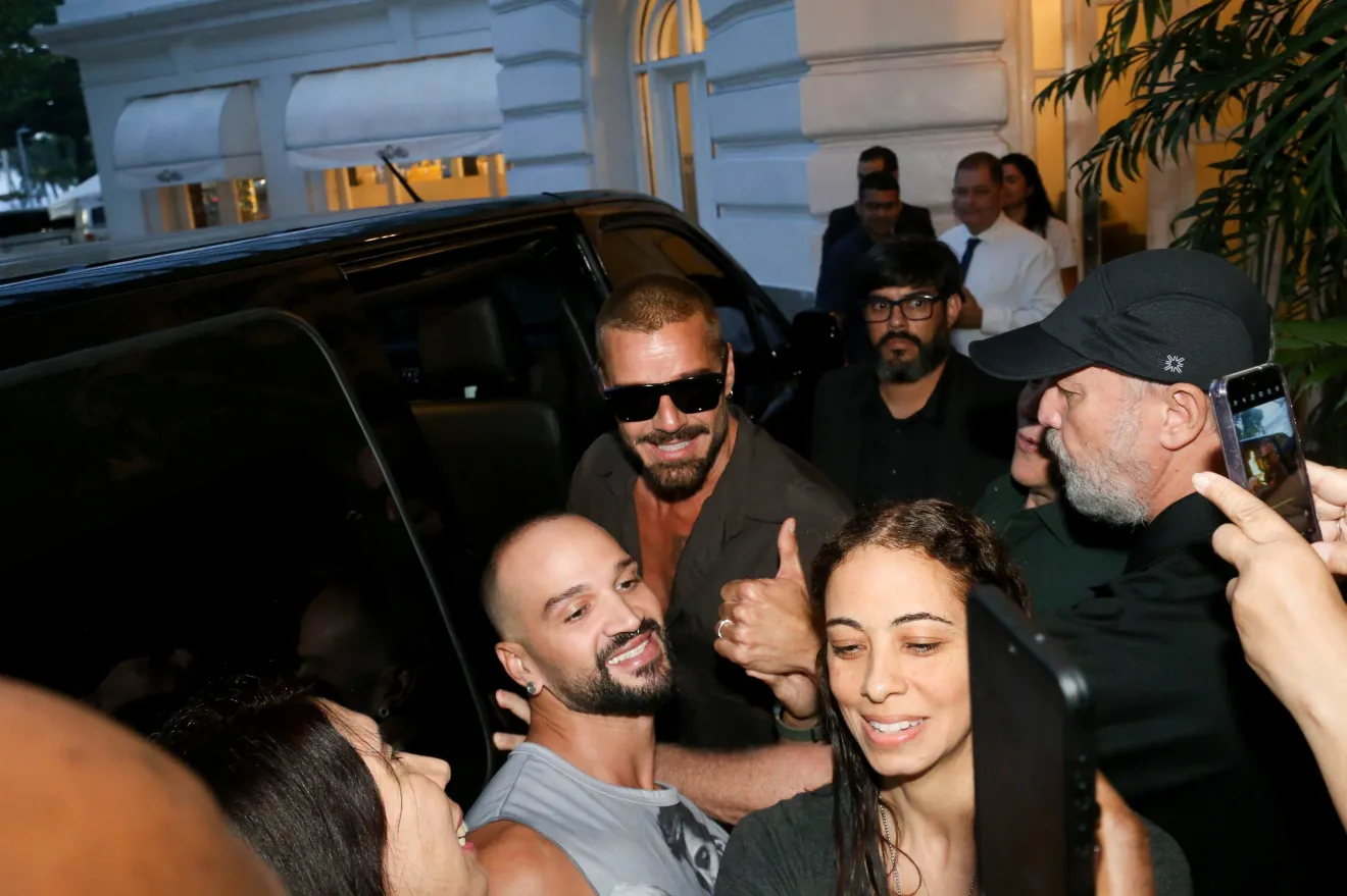 Ricky Martin no Rio de Janeiro: cantor atende fãs ao deixar hotel 6 Ricky Martin de óculos escuros e camisa escura faz joinha para foto com fãs na saída de hotel no Rio de Janeiro