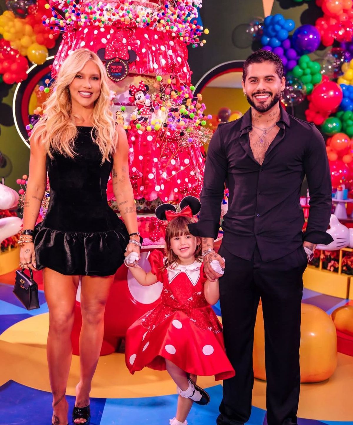 Reconciliação à vista? Virginia e Zé Felipe chegam e vão embora juntos na festa de 5 anos de Maria Alice 6 Casal posa de mãos dadas com uma criança fantasiada diante da decoração de festa de aniversário