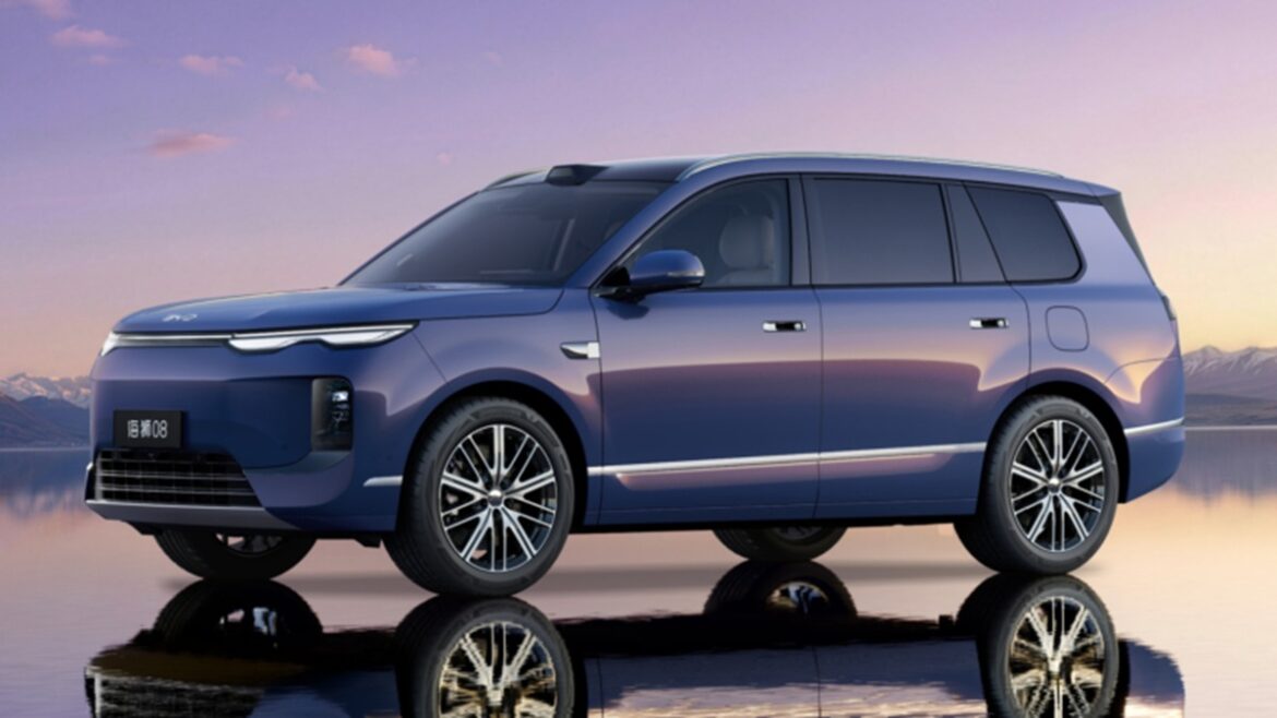 SUV elétrico BYD Sealion 08 azul visto de perfil lateral em cenário montanhoso com reflexo em superfície espelhada
