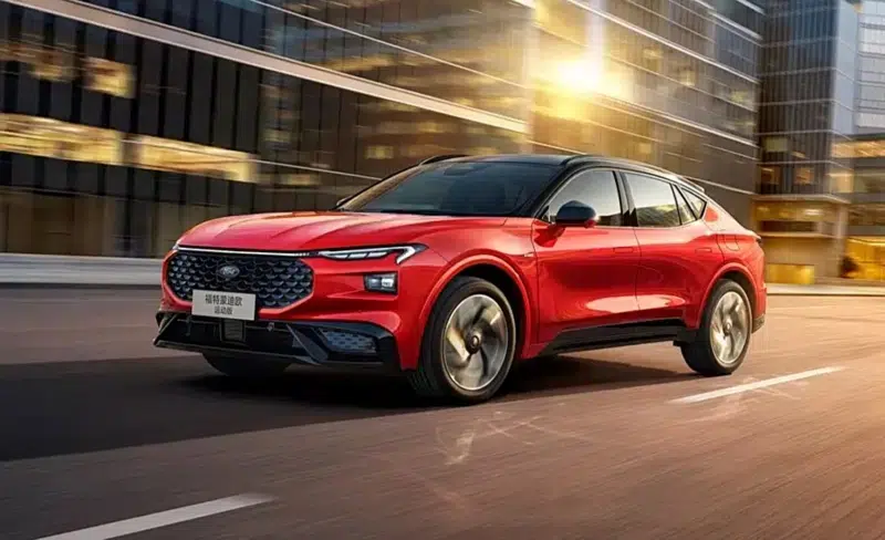 Ford Mondeo Sport híbrido 2026 estreia na China com 308 cv e autonomia de 915 km por 31 mil dólares 6 Ford Mondeo Sport Edition híbrido vermelho em rua urbana chinesa com prédios espelhados ao fundo e iluminação dourada