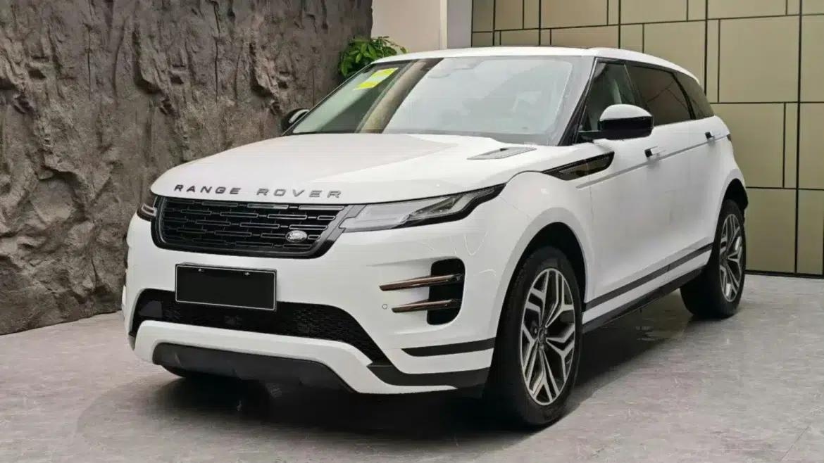 SUV Range Rover Evoque L branco estacionado em showroom com parede de pedra e piso de mármore cinza na China