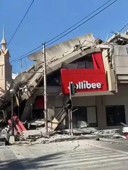 Vídeo: Câmera flagra reação de alunos durante terremoto; assista 6 Prédio de restaurante Jollibee parcialmente colapsado com fachada vermelha visível entre escombros de concreto em General Santos