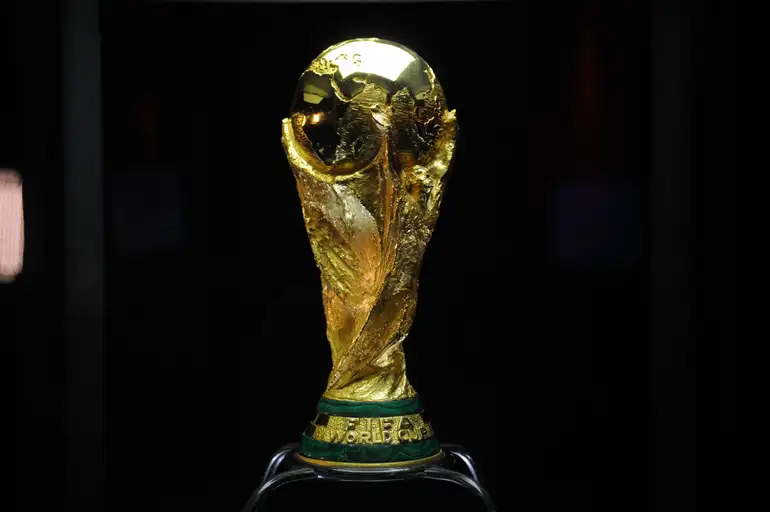 Copa 2026: Haaland, algoz do Brasil, encara Kane por vaga na semifinal 6 Taça dourada da Copa do Mundo FIFA exposta em pedestal com fundo escuro