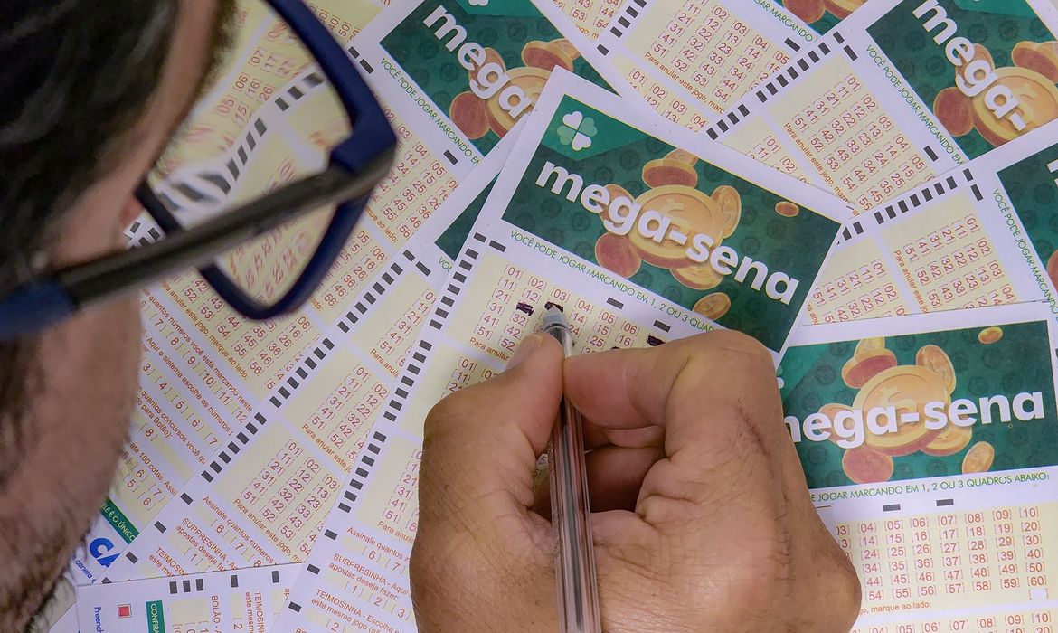 Mega-Sena: aposta de Petrolina crava a quina e leva R$ 28.109,79; prêmio acumulado vai a R$ 78 milhões 6 Homem com óculos marca números em bilhete da Mega-Sena cercado de volantes de loteria